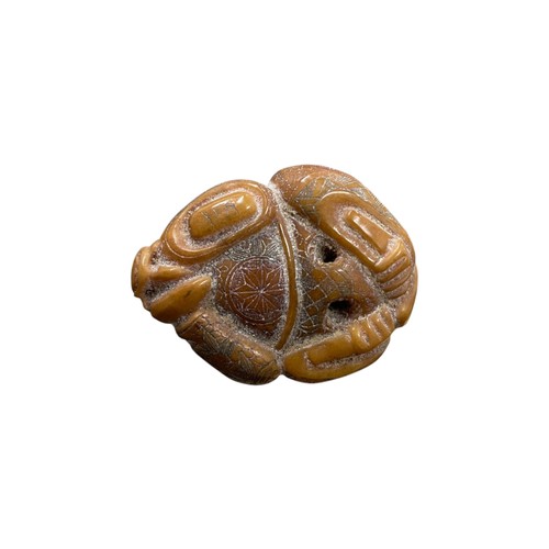 273 - Japanese amber netsuke in the form of a deity with highly intricate carved detail, signature inscrib... 