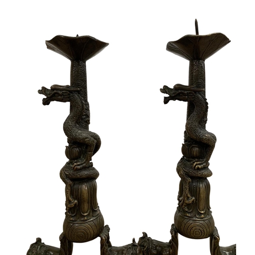 288 - Pair of Qing Dynasty bronze candle holders with crisp detailing, each comprising two Foo dogs standi... 