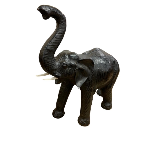 1465 - Pair of black leather elephant sculptures, in the manner of Liberty, each having original faux ivory... 