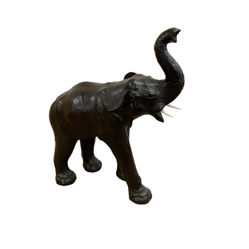 1465 - Pair of black leather elephant sculptures, in the manner of Liberty, each having original faux ivory... 