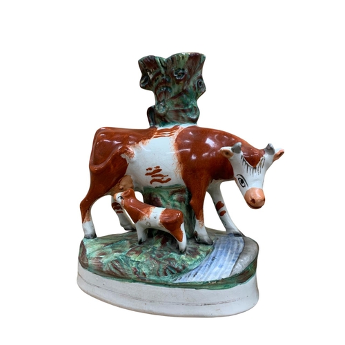 396 - Pair of hand painted Staffordshire spill vases depicting cow and suckling calf, H 27cm