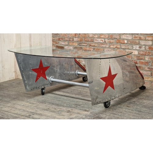 1216 - Vintage bespoke aviation desk with glass top made from aluminium plane parts raised on wheels, H 77c... 