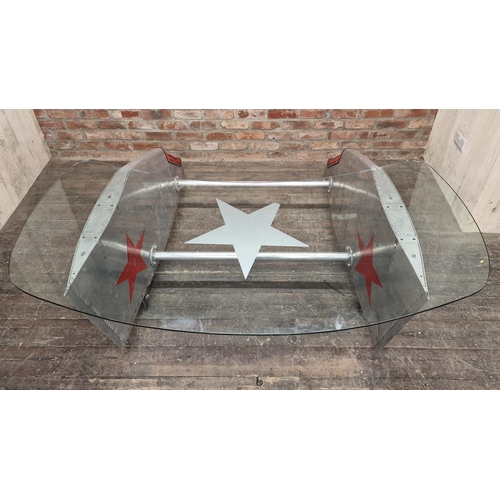 1216 - Vintage bespoke aviation desk with glass top made from aluminium plane parts raised on wheels, H 77c... 