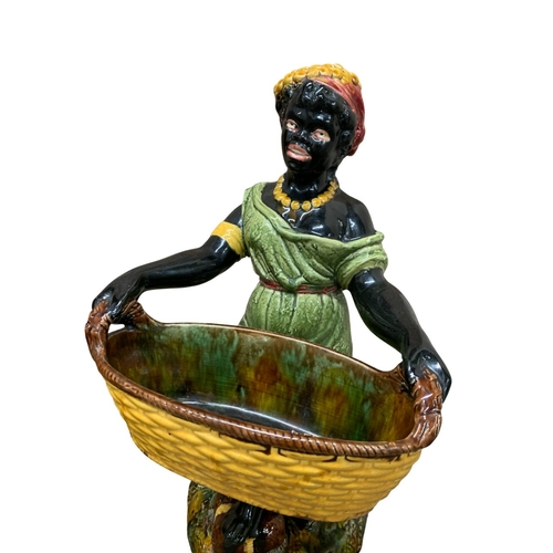 407 - Pair of large majolica Blackamoor figures, harvesting couple holding woven baskets atop naturalistic... 