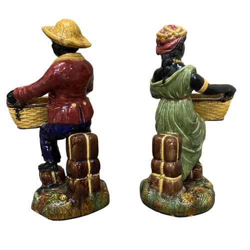 407 - Pair of large majolica Blackamoor figures, harvesting couple holding woven baskets atop naturalistic... 