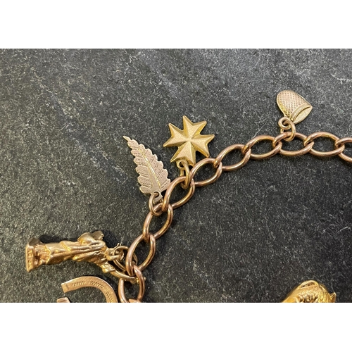 26 - Comprehensive 9ct charm bracelet, with full 1911 sovereign and various charms to include St Bernadet... 