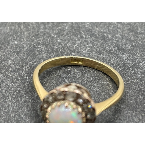 36 - 18ct opal and diamond dress ring, central 1.2ct opal framed by fourteen brilliant diamonds, size S, ... 