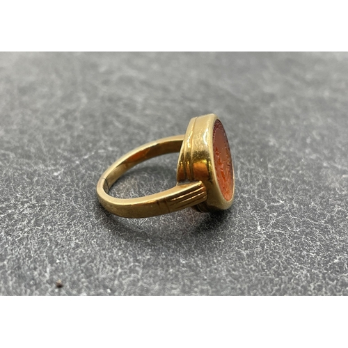 51 - Antique unmarked high carat gold carnelian seal ring, carved with a cherub walking dogs in a landsca... 