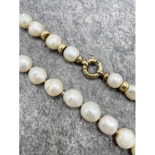 94 - Cultured freshwater pearl single row necklace. The 30 graduated baroque-shaped pearls knotted with s... 