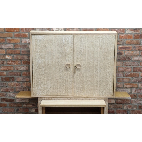 1418 - 20th century limed oak two door drinks cabinet with shelved interior, the base with hinged compartme... 