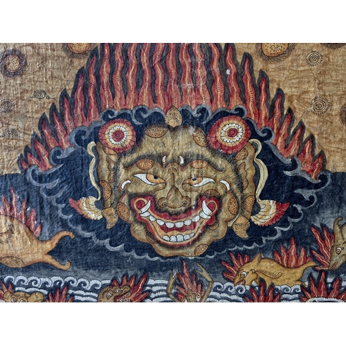 304 - Large Balinese temple wall hanging, with various dieties in orange and red, 126 x 184cm, frame