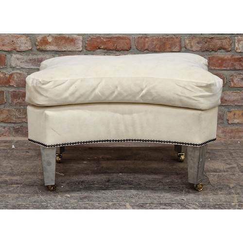 1308 - Contemporary armchair and footstool with studded upholstery raised on brass castors, H 108cm x W 88c... 