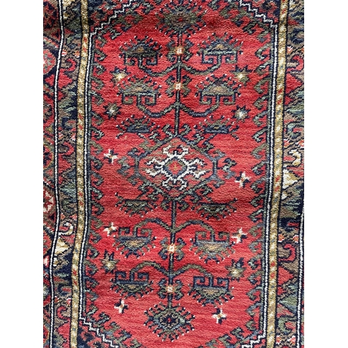 1757 - Kurdish runner, floral medallion, red ground, 140cm x 70cm