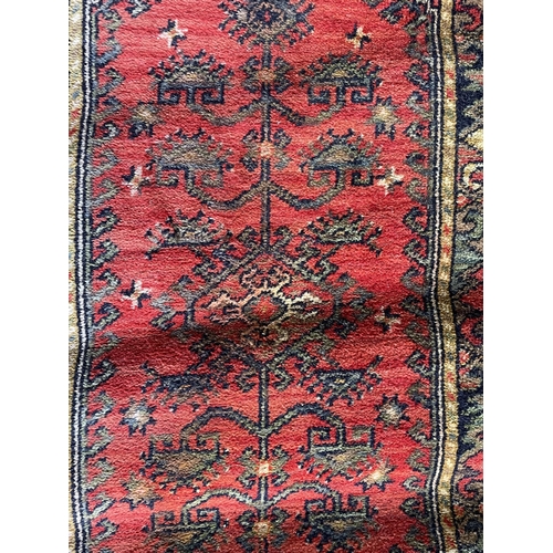 1759 - Kurdish runner, floral medallion, red ground, 130cm x 70cm