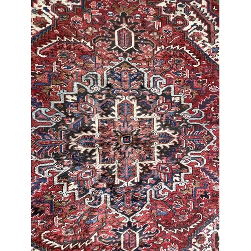 1764 - Good Persian Heriz carpet, blue floral design on red ground, 310cm x 220cm