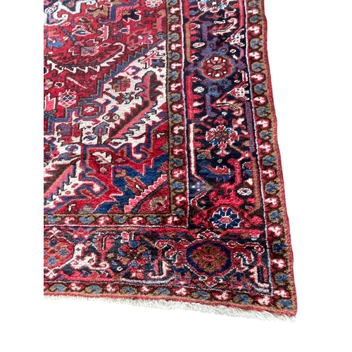 1764 - Good Persian Heriz carpet, blue floral design on red ground, 310cm x 220cm