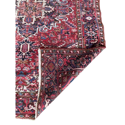 1764 - Good Persian Heriz carpet, blue floral design on red ground, 310cm x 220cm