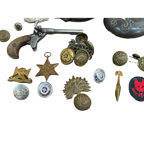 223 - Mixed assortment of military and shooting related pieces to include buttons, medals, cap badges, tre... 