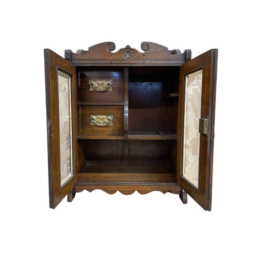 464 - Edwardian oak smokers cabinet, having bevelled glass panes enclosing a fitted twin draw interior ado... 