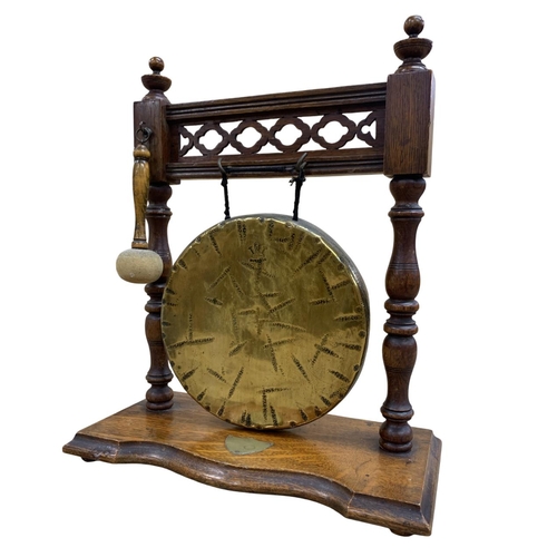 480 - Oak and brass table gong with striker, raised atop four footed base with columned sides and pierced ... 