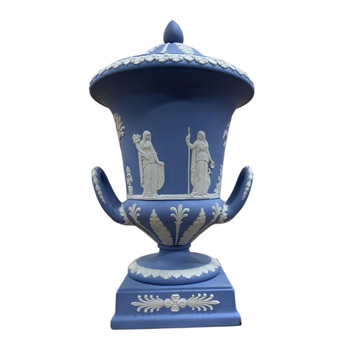 409 - Wedgwood blue jasperware twin handled Campana urn and cover with classical relief decoration ,H 30cm