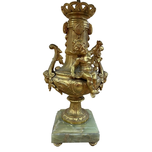 1072 - Impressive Ormolu cherub adorned table lamp, raised atop a four footed onyx base having ornate acant... 