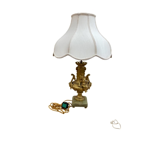 1072 - Impressive Ormolu cherub adorned table lamp, raised atop a four footed onyx base having ornate acant... 