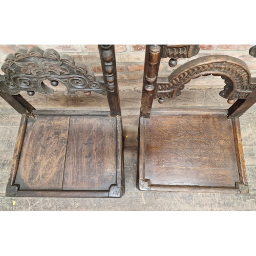 1325 - Two similar 17th century carved oak hall chairs with solid seats, H 103cm x W 49cm x D 41cm (2)