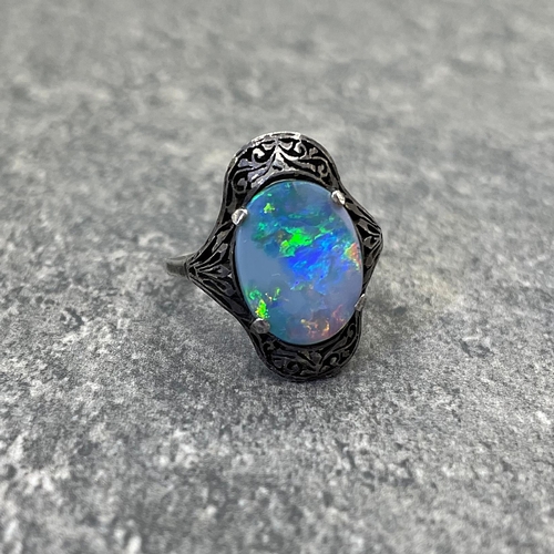 69 - Early 20th century opal and white metal ring, the opal doublet set in a pierced mount, size N