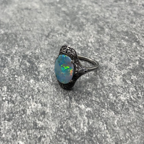 69 - Early 20th century opal and white metal ring, the opal doublet set in a pierced mount, size N