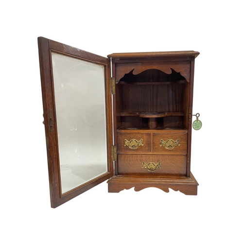 502 - Edwardian oak smokers cabinet with bevelled glazed door and fitted three draw interior having origin... 