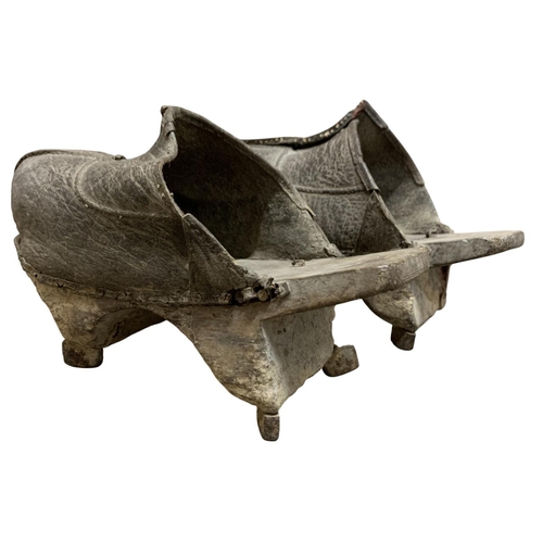 357 - An antique pair of Chinese rice paddy field leather clogs, raised on wooden platforms with metal stu... 