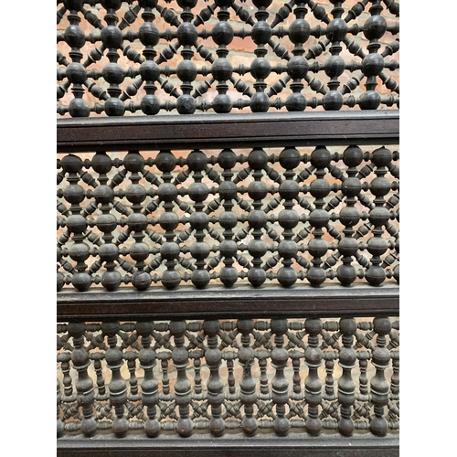 1424 - An antique Moorish intricate beaded fire screen with carved geometric lower panel, raised on twin su... 