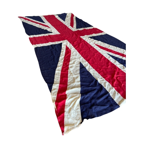 597 - Quantity of very large Union Jack stitched canvas flags, possibly maritime, having original wooden t... 