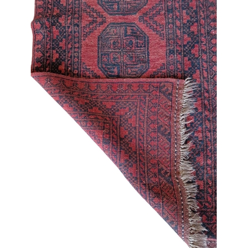 1697 - Bokhara runner with central geometric medallions, on a red ground, 301cm x 89cm