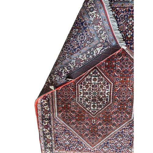 1682 - Good Persian rug with intricate handstitched detail on deep red ground, 140cm x 90cm