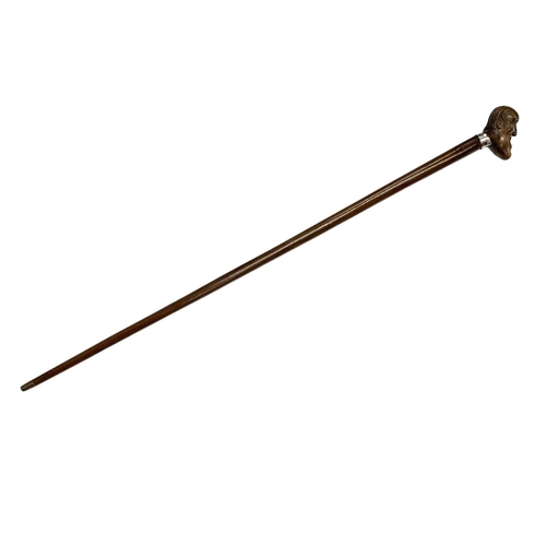 645 - Hardwood walking cane with carved laughing head handle, having a silver plated shirt-shaped collar w... 