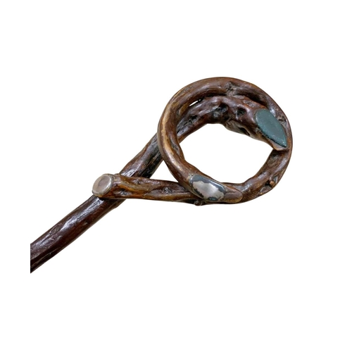 657 - Crude Folk Art walking stick of curled river wood, having three white metal metal inlays to handle a... 