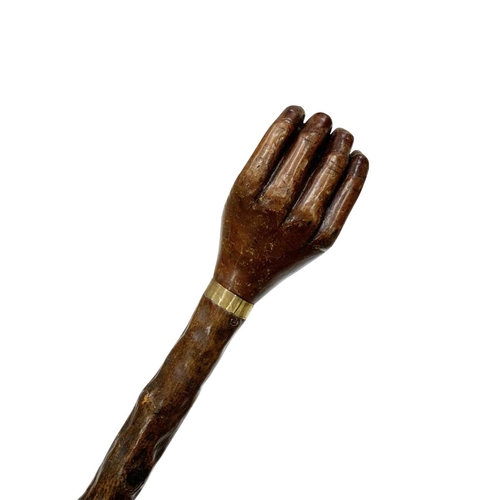 661 - Folk Art hazel wood walking cane with handle carved as a hand holding a ball, with thin metal collar... 