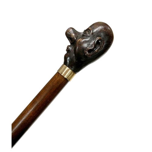 667 - Hardwood walking cane with handle carved as caricature man's head, having marked 9ct gold-plated col... 