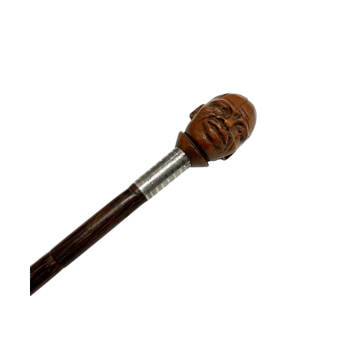 671 - Stepped partridge wood walking cane with coquilla nut-handle carved as a man's head, having silver m... 