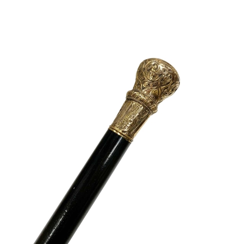 673 - Ebonised hardwood walking cane with gilt embossed and chased metal handle, L 89cm