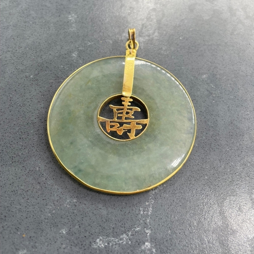 56 - Chinese jade disc pendant with 14ct mounts, 4.8cm diameter. 16.5g gross.