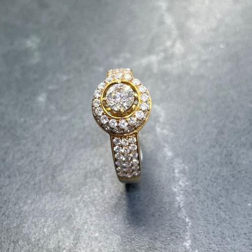 54 - Impressive '750' and diamond halo ring, central stone .5ct, framed by smaller diamonds with further ... 