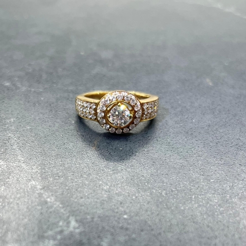 54 - Impressive '750' and diamond halo ring, central stone .5ct, framed by smaller diamonds with further ... 