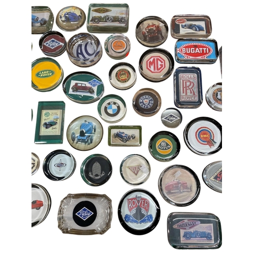 61 - An extensive collection of automobilia car related glass paperweights to include Bugatti, Land Rover... 