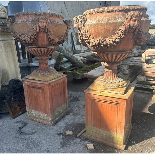 236 - Good quality pair of terracotta urns with classical maiden mask detail, floral swags and darted rims...
