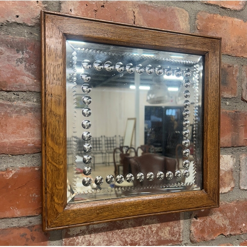 61 - Sorcerer's style wall mirror with bevelled and beaded glass decoration and oak frame surround, 31cm ... 