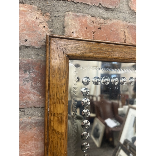 61 - Sorcerer's style wall mirror with bevelled and beaded glass decoration and oak frame surround, 31cm ... 