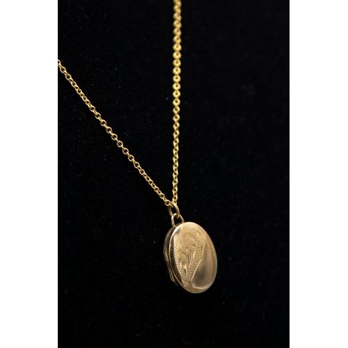 42 - A vintage 9ct gold small oval locket and chain, the locket part foliate engraved and with hallmarks ... 